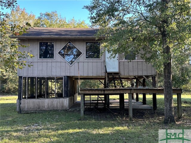 rear view of property with a deck and a lawn