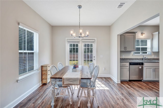 dining room featuring dark hardwood / wood-style floors, plenty of natural light, sink, and a notable chandelier