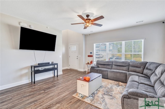 living room with a textured ceiling, hardwood / wood-style floors, and ceiling fan