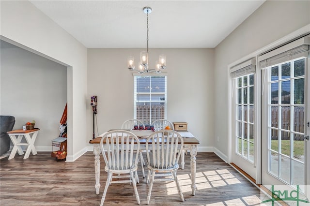 dining room featuring a wealth of natural light, dark hardwood / wood-style floors, and a notable chandelier