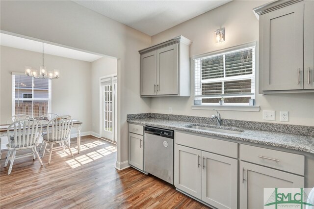 kitchen featuring light wood-type flooring, a wealth of natural light, gray cabinets, and stainless steel dishwasher