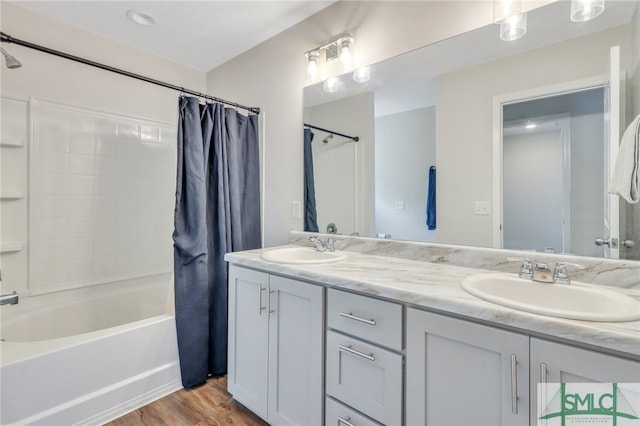 bathroom featuring hardwood / wood-style flooring, vanity, and shower / bath combo with shower curtain