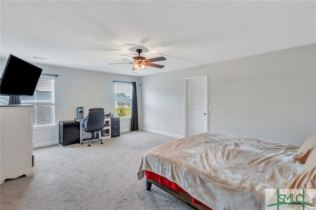 carpeted bedroom with ceiling fan and a textured ceiling