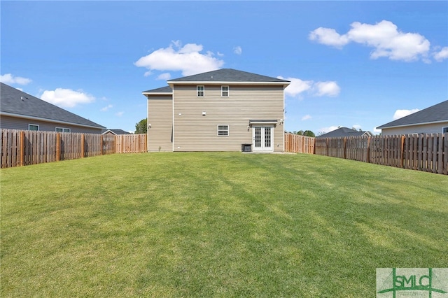 back of house featuring a yard and french doors