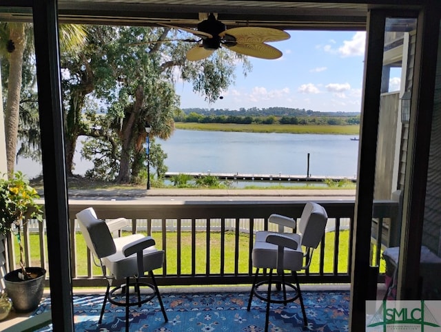 balcony with a water view and ceiling fan