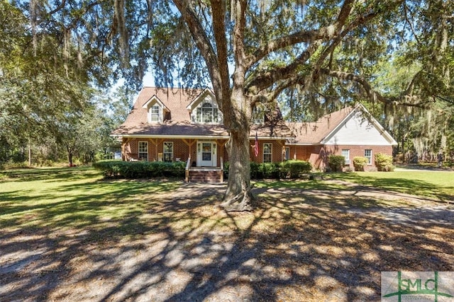 cape cod home with covered porch and a front yard