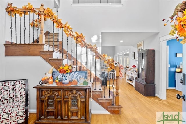 staircase featuring hardwood / wood-style floors and a high ceiling