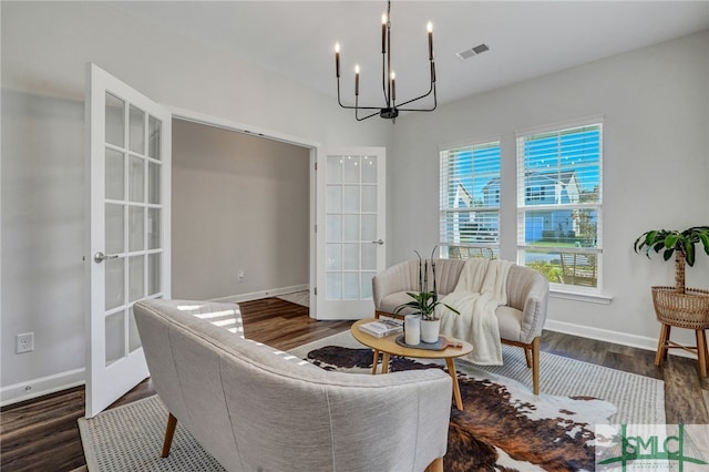 living room featuring french doors, a chandelier, and dark hardwood / wood-style flooring