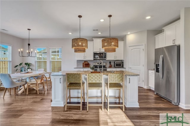 kitchen featuring a center island with sink, white cabinetry, appliances with stainless steel finishes, and plenty of natural light