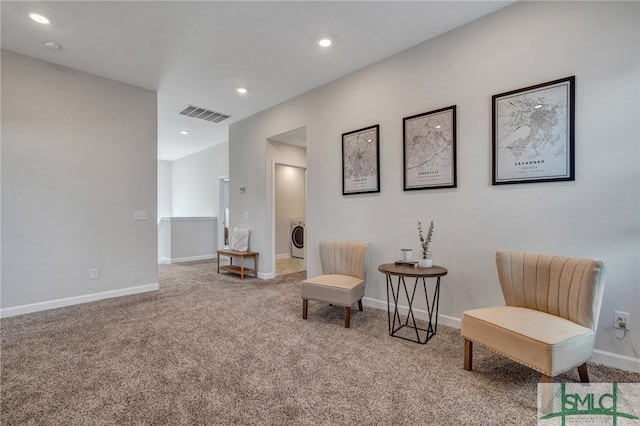 sitting room with washer / clothes dryer and carpet