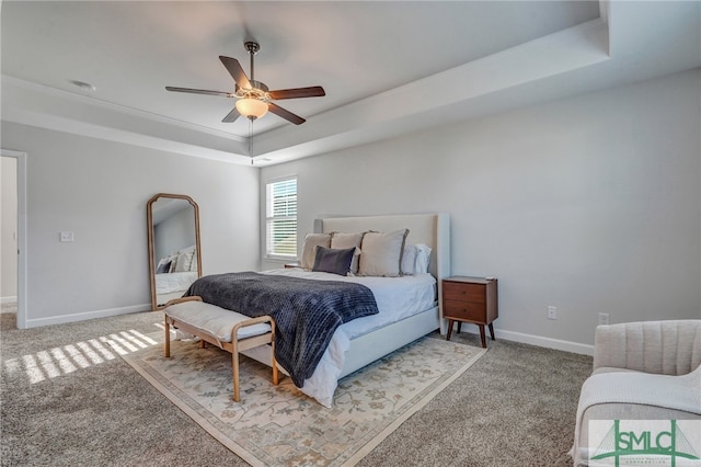 bedroom featuring ceiling fan, carpet floors, and a tray ceiling