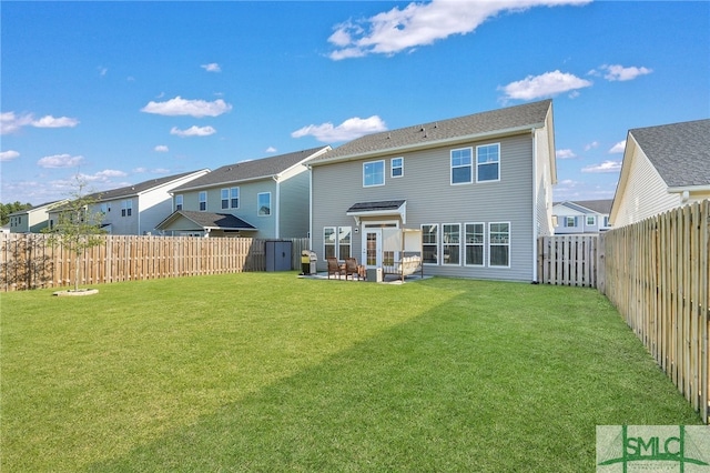 rear view of property featuring a patio and a lawn