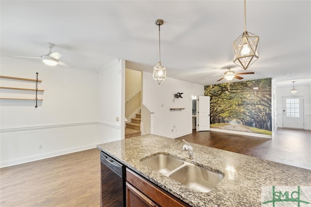 kitchen with light stone counters, black dishwasher, sink, and wood-type flooring