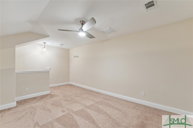 carpeted empty room with ceiling fan and vaulted ceiling