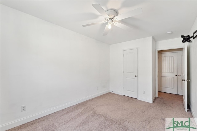 unfurnished bedroom featuring a closet, light colored carpet, and ceiling fan