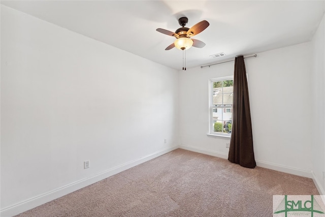 spare room with ceiling fan and light colored carpet