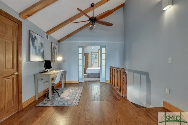 home office with beam ceiling, high vaulted ceiling, ceiling fan, and wood-type flooring