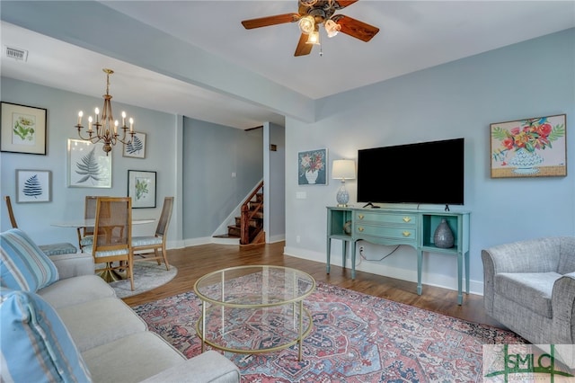 living room featuring ceiling fan with notable chandelier and hardwood / wood-style floors