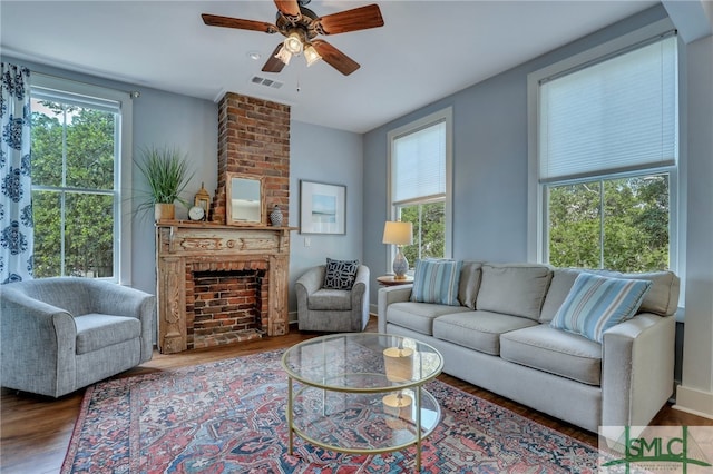 living room featuring ceiling fan, hardwood / wood-style flooring, a fireplace, and a wealth of natural light