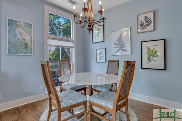 dining area with an inviting chandelier and dark hardwood / wood-style flooring