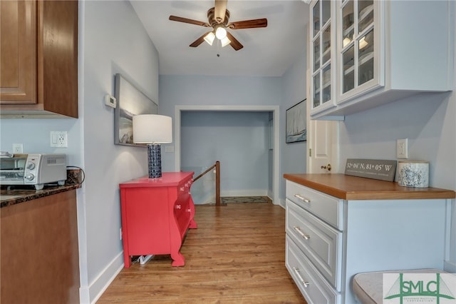 kitchen with ceiling fan, white cabinets, and light hardwood / wood-style floors