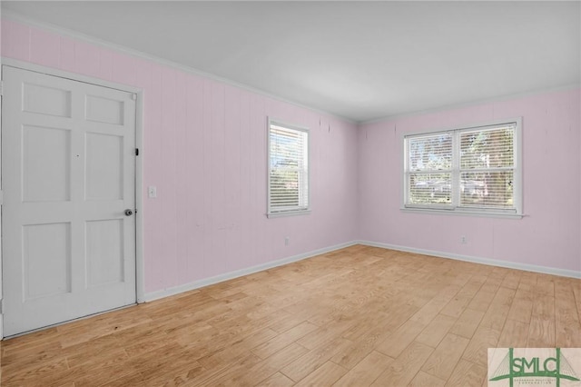 empty room with crown molding and light hardwood / wood-style flooring