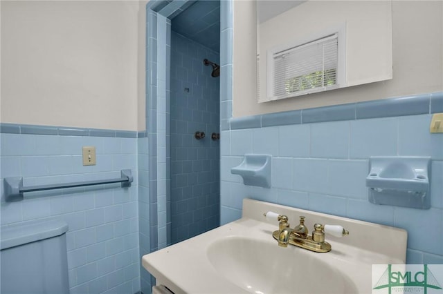 bathroom with vanity, toilet, and tile walls