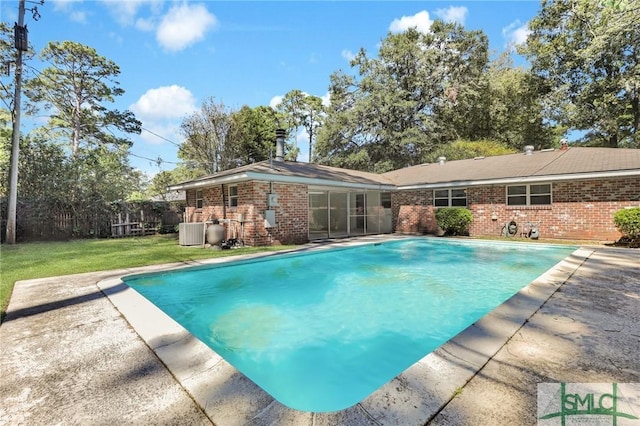 view of swimming pool with a yard and central AC unit