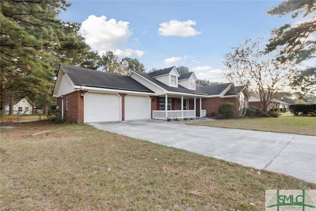 new england style home with a porch, a front lawn, and a garage