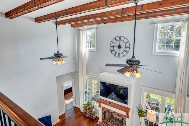 room details featuring beam ceiling, wood-type flooring, and ceiling fan