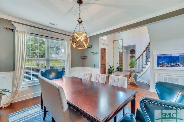 dining space featuring crown molding, a notable chandelier, and hardwood / wood-style floors