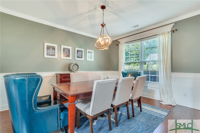 dining space featuring crown molding and dark wood-type flooring