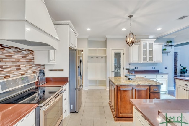 kitchen with appliances with stainless steel finishes, custom range hood, decorative light fixtures, and white cabinets