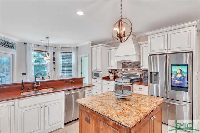 kitchen with white cabinets, appliances with stainless steel finishes, and hanging light fixtures