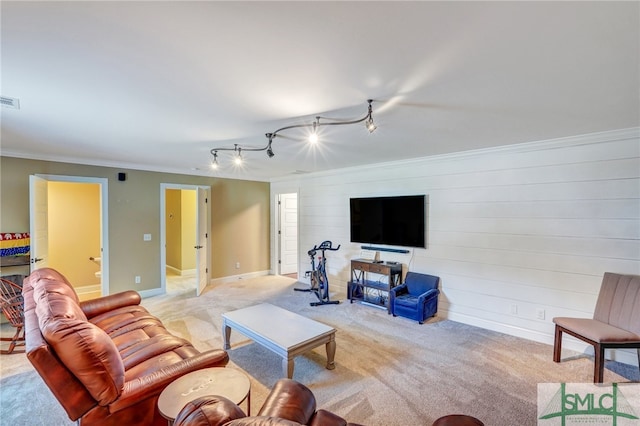 carpeted living room with rail lighting and crown molding