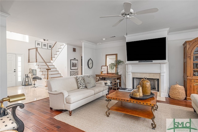 living room featuring dark hardwood / wood-style floors, ceiling fan, and crown molding