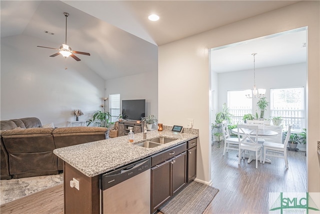 kitchen featuring sink, light hardwood / wood-style floors, lofted ceiling, stainless steel dishwasher, and light stone counters