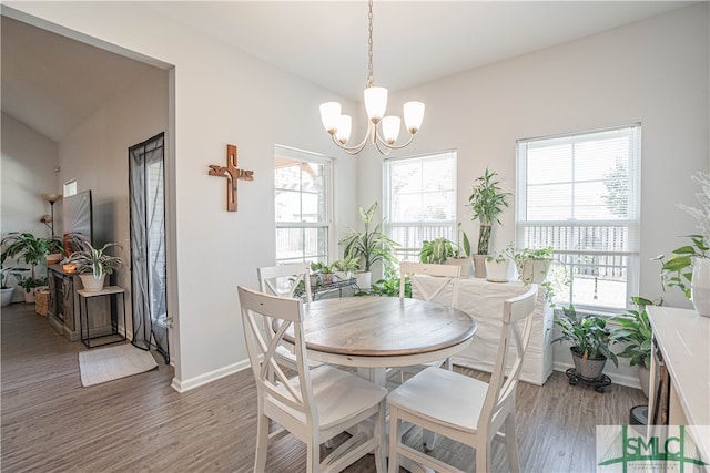 dining room with a wealth of natural light, wood-type flooring, and an inviting chandelier