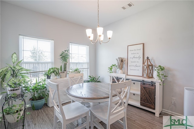 dining room featuring hardwood / wood-style flooring and an inviting chandelier