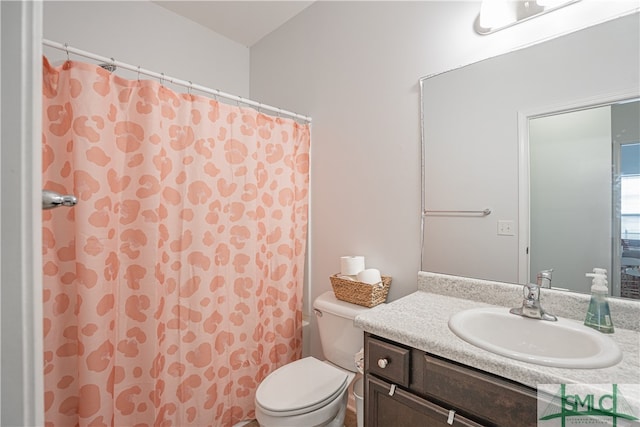 bathroom featuring vanity, curtained shower, and toilet