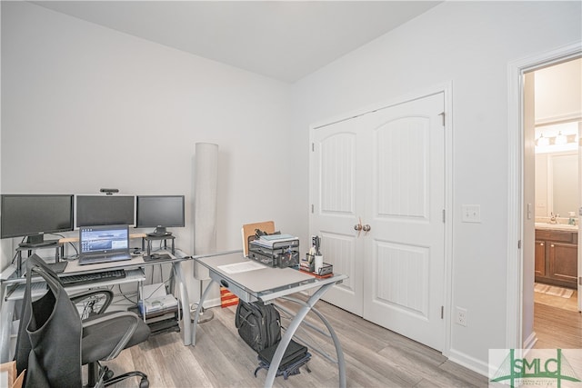 office area featuring sink and light wood-type flooring