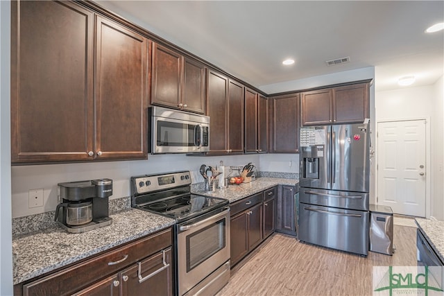 kitchen featuring light stone countertops, appliances with stainless steel finishes, and dark brown cabinets