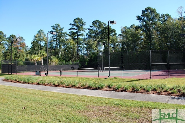 view of tennis court featuring a lawn