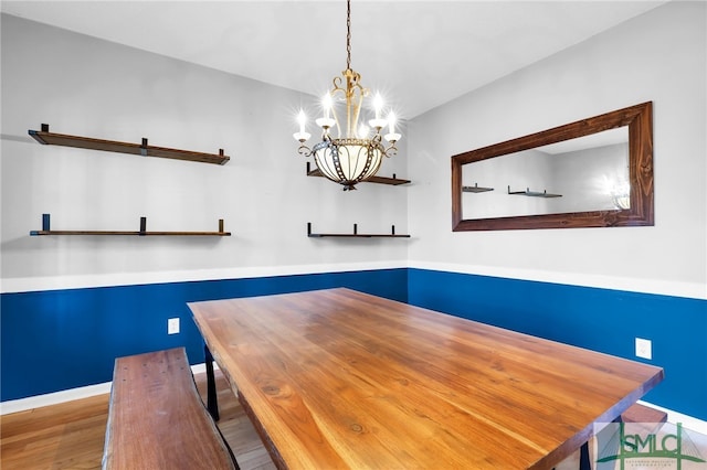 unfurnished dining area with hardwood / wood-style flooring and a notable chandelier