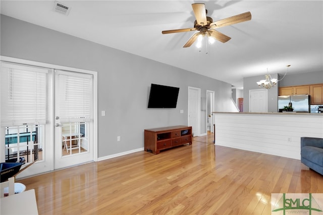 living room featuring light hardwood / wood-style floors and ceiling fan with notable chandelier