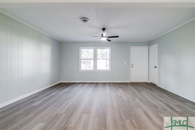 empty room featuring light hardwood / wood-style flooring, ornamental molding, and ceiling fan