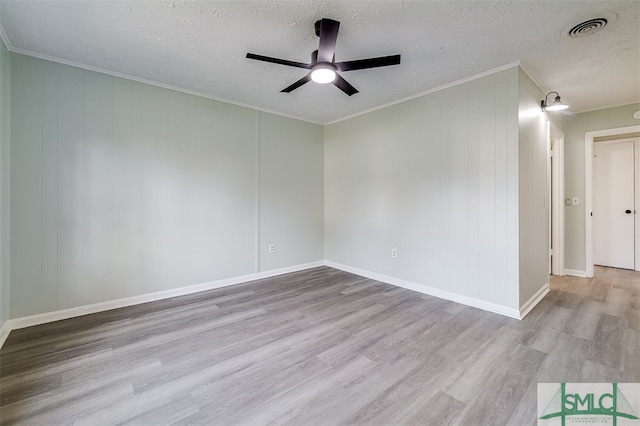 empty room with ornamental molding, light hardwood / wood-style flooring, a textured ceiling, and ceiling fan