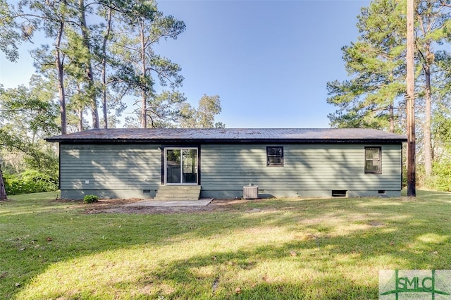 back of property featuring central air condition unit and a lawn