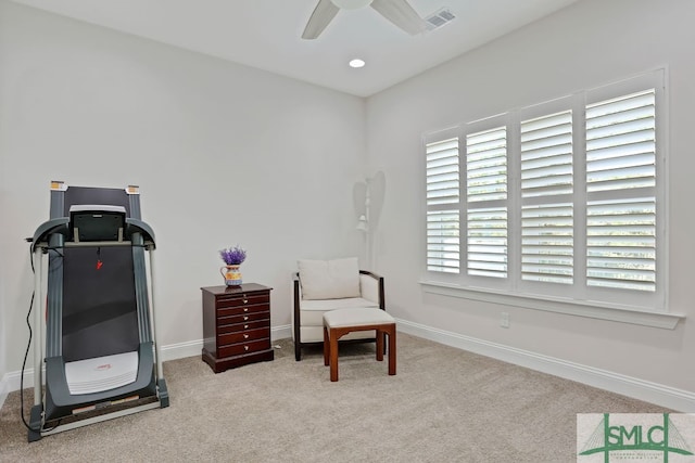 living area with light colored carpet and ceiling fan