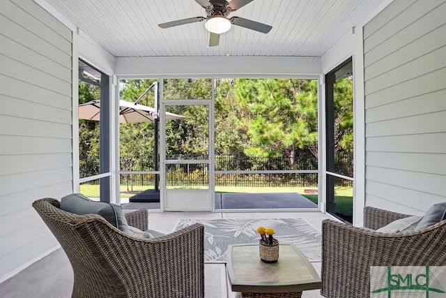 sunroom / solarium featuring wood ceiling, a healthy amount of sunlight, and ceiling fan